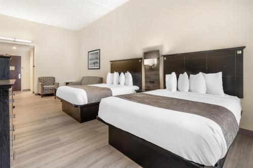 a hotel room with two beds and a chair at Best Western Bar Harbour Inn in Massapequa Park