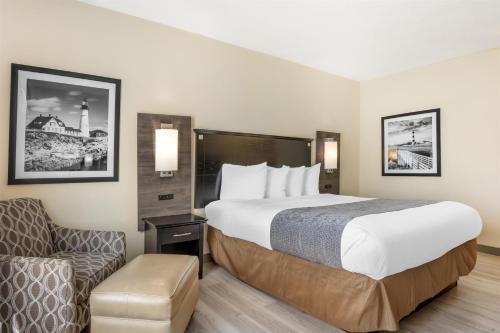 a hotel room with a bed and a chair at Best Western Bar Harbour Inn in Massapequa Park