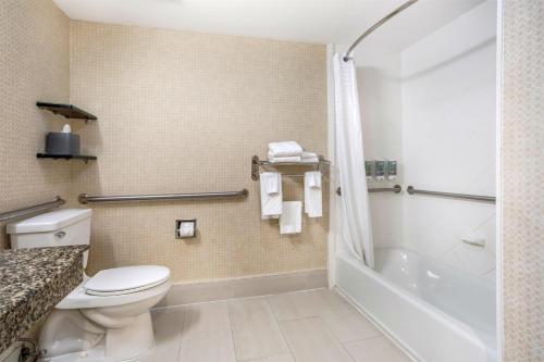 a bathroom with a toilet and a tub and a shower at Best Western Bar Harbour Inn in Massapequa Park
