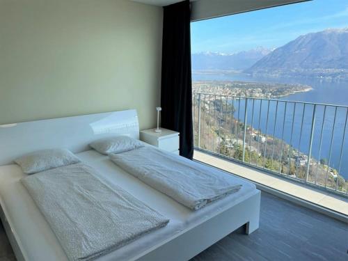 Un dormitorio con una cama y una ventana grande. en 1-bedroom holiday home, en Arcegno