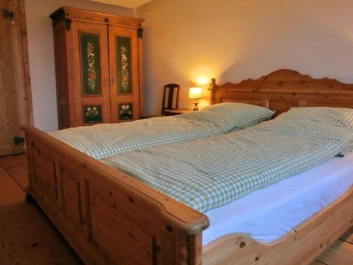 ein großes Bett in einem Schlafzimmer mit einem Holzrahmen in der Unterkunft Black Forest farmhouse Bernau in Bernau im Schwarzwald