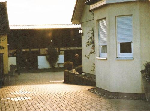 a house with a brick driveway next to a building at Fuhrmann Comfortable holiday residence in Neustrelitz