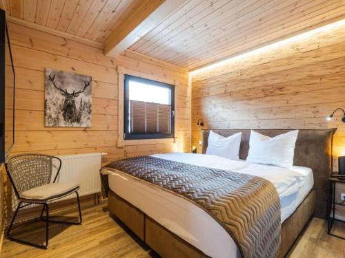 Un dormitorio con una cama y una silla en una habitación. en Mountain Forest Chalet Comfort 3, en Schierke