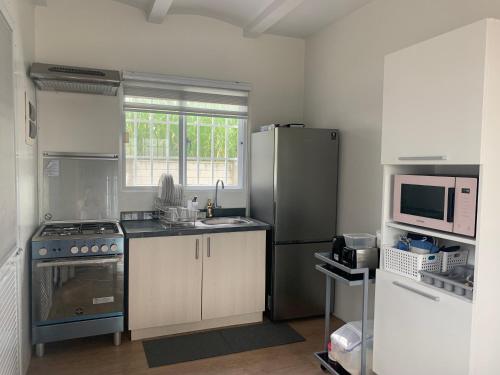 Una cocina con estufa, fregadero y microondas. en bluehouse csfp, en San Fernando