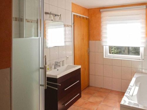 a small bathroom with a sink and a window at Holiday apartment with 3 bedrooms in Enzklösterle