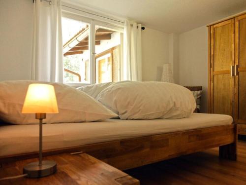 a bedroom with a bed with a window and a lamp at Holiday apartment with 3 bedrooms in Enzklösterle