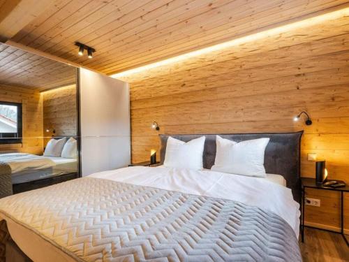 une chambre avec un grand lit avec un mur en bois dans l'établissement Bergwaldchalet Wellness 6, à Schierke