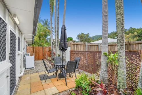 a patio with a table and chairs and a fence at Belle Escapes Relax Rose in Palm Cove