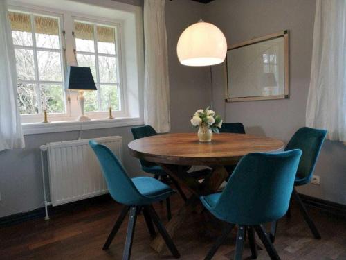 a dining room with a wooden table and blue chairs at Schroeder's House Kampen House 2 in Kampen