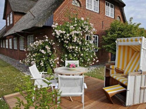 a patio with a table and chairs and a building at Schroeder's House Kampen House 2 in Kampen