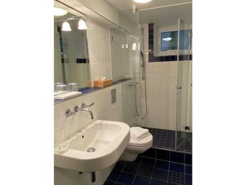 a bathroom with a sink and a toilet and a shower at Schroeder's House Kampen House 2 in Kampen