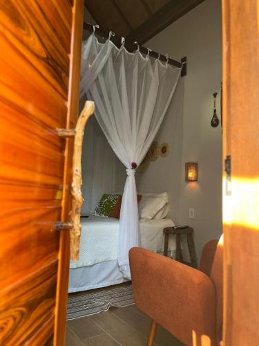 a bedroom with a bed with a white canopy at POUSADA NOSSO CANTO ALTER in Alter do Chao