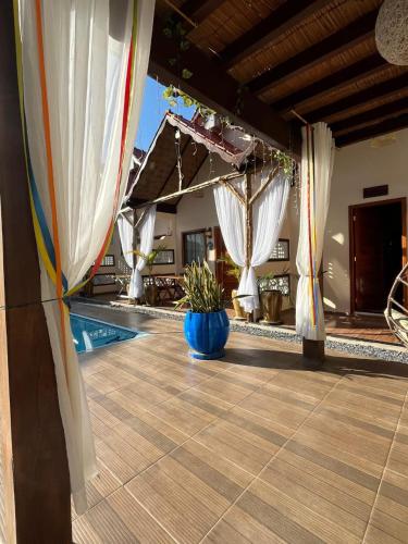 a patio with white curtains and a swimming pool at POUSADA NOSSO CANTO ALTER in Alter do Chao