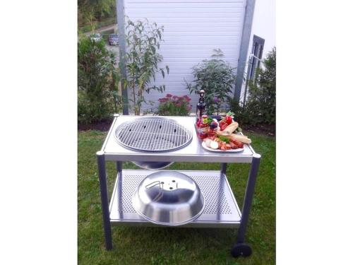 a barbecue cart with a grill and a plate of food at Holiday home with 2 bedrooms in Göhren-Lebbin