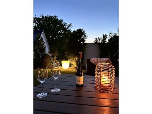 a bottle of wine and two glasses on a wooden table at Holiday home with 2 bedrooms in Göhren-Lebbin