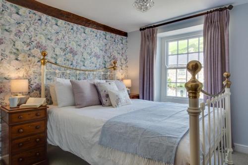 Un dormitorio con una cama blanca y una ventana. en Memories Cottage, en Milnthorpe