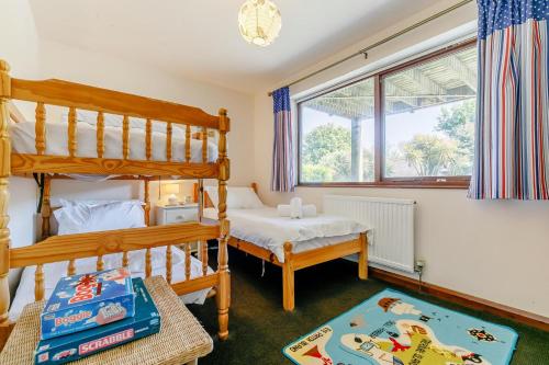 Un dormitorio con dos literas y una ventana. en Milton Lodge, en Little Petherick