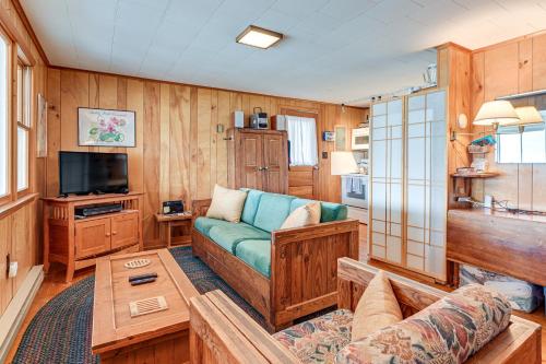a living room with a couch and a tv at Dock and Rowboat Beechnut Bungalow on Keuka Lake in Branchport