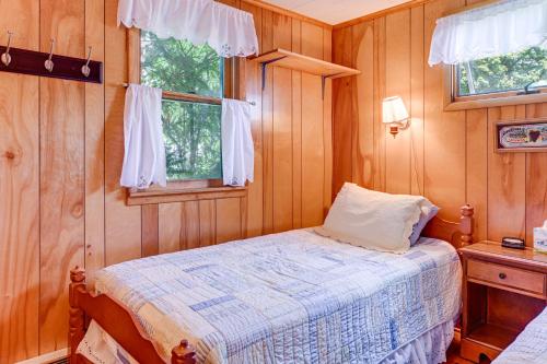 a bedroom with a bed and two windows at Dock and Rowboat Beechnut Bungalow on Keuka Lake in Branchport