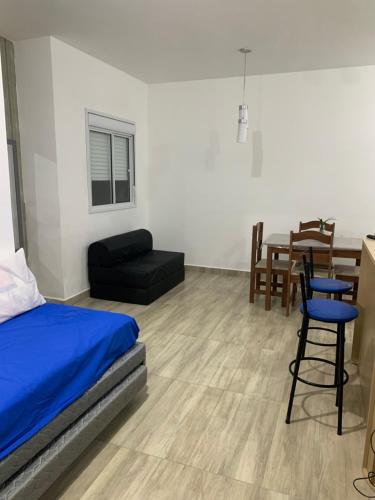 a bedroom with a bed and a table and chairs at Apartamento de frente ao mar in Mongaguá
