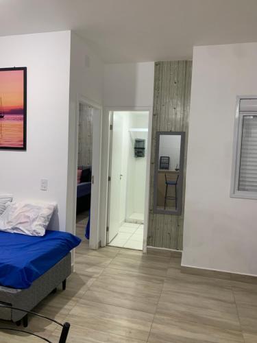 a bedroom with a bed and a hallway with a mirror at Apartamento de frente ao mar in Mongaguá