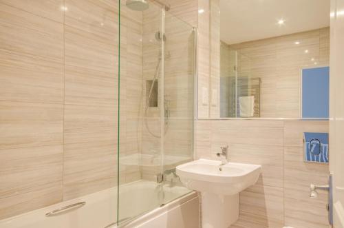 Un baño con ducha, lavabo e inodoro. en Allseasons, en Fowey
