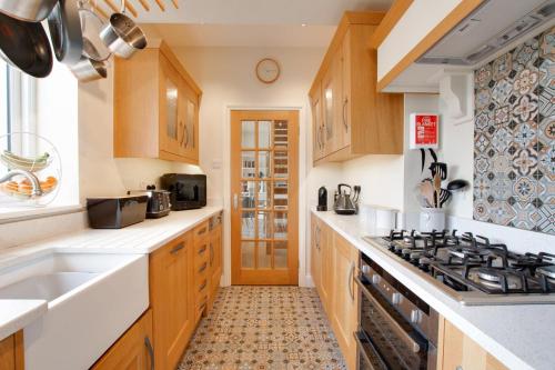 a kitchen with wooden cabinets and a stove top oven at Honey Cottage in Richmond