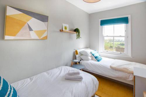 a bedroom with two beds and a window at Honey Cottage in Richmond