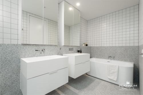 a white bathroom with two sinks and a mirror at Platinum Luxury Stays at Aston in Melbourne
