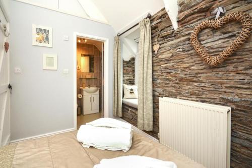 a room with a stone wall with a heart on it at Tregerrick in Padstow