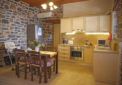 a kitchen with a table and chairs in a room at Kalo Nero Apartments in Makry Gialos