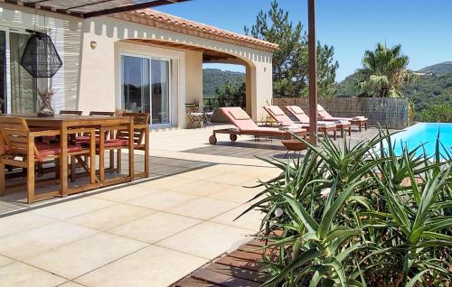 un patio avec une table et des chaises à côté d'une piscine dans l'établissement Awesome Home In St Nazaire De Ladarez, à Saint-Nazaire-de-Ladarez