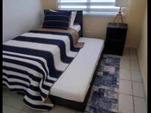 two beds sitting in a room with a window at Cozy Cute Home 2nd floor pay at the property and we have many method of payments just ask us in Fajardo
