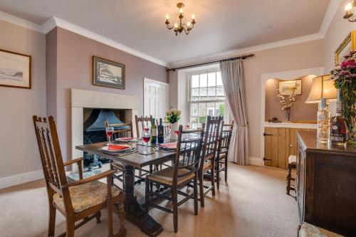 a dining room with a table and chairs and a fireplace at Littlebeck in Kettlewell