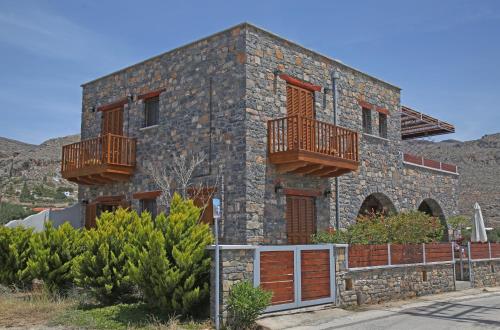a stone house with two balconies on it at Kalo Nero Apartments in Makry Gialos