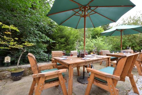 a wooden table and chairs with an umbrella at Littlebeck in Kettlewell