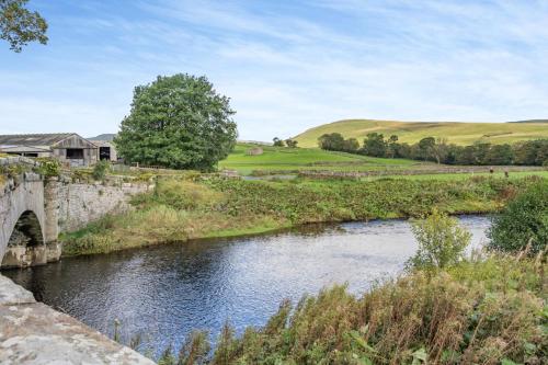 an old bridge over a river in a field at Hill View in Appersett