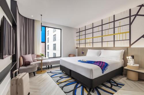 a hotel room with a bed and a large window at Hotel Indigo Melbourne Little Collins in Melbourne