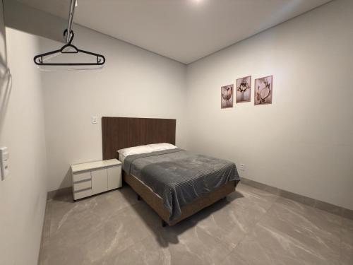 a bedroom with a bed in a white room at Apartamento completo e bem localizado in Sinop