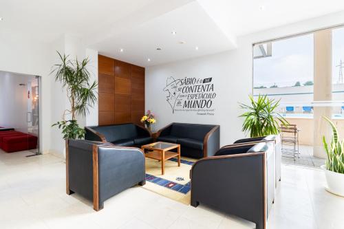 a waiting room with couches and plants at Hotel La Fontaine in Esmoriz