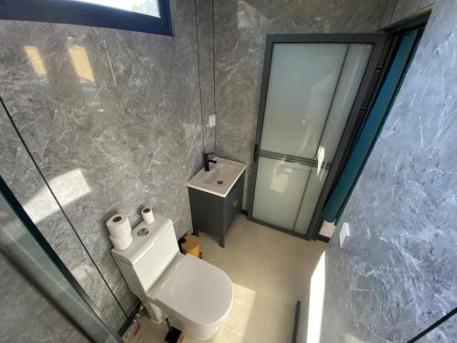 a bathroom with a toilet and a glass shower at MOOREA - Naku Kahi Bungalow 2 in Maatea