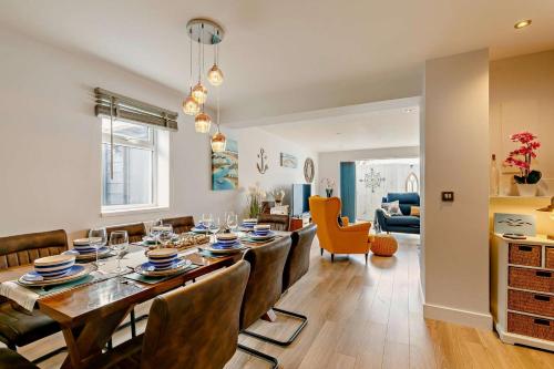 a dining room and living room with a table and chairs at Coastal Dreams in St Ives