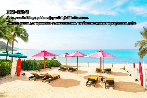 a beach with chairs and umbrellas and the ocean at InterContinental Sanya Resort by IHG in Sanya