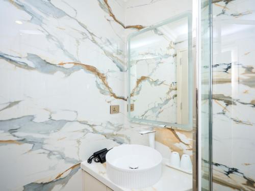 a bathroom with a marble wall at Hanoi Ivory Hotel in Hanoi