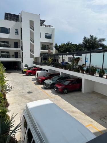 a parking lot with cars parked in front of a building at Luxor and Condo Hotel in Ajijic