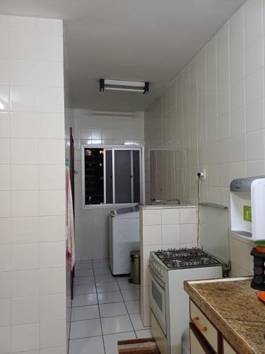 Una pequeña cocina con estufa y fregadero. en Apartamento inteiro Cop 30, en Belém