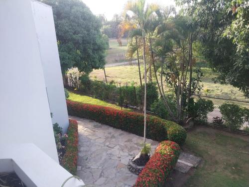 a view of a garden with red and white flowers at Tropical Optimal Tropicana Sur in Sosúa