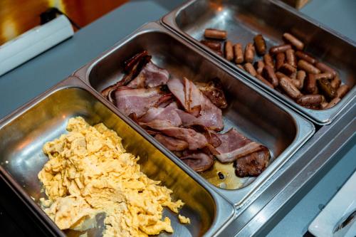 a tray of food with bacon and other foods at Hotel La Fontaine in Esmoriz