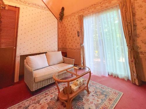 a living room with a chair and a window at Pension Balmy in Nasu