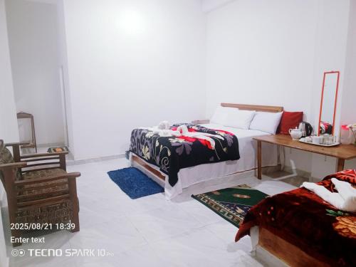 a bedroom with two beds and a wooden table at Korean motel in Ohiya